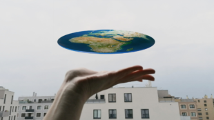 Erde als eine Scheibe auf einer Hand